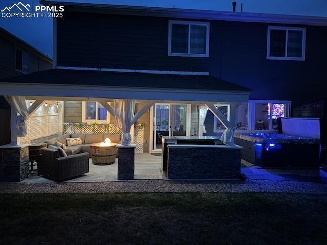 Image 4 of 37: Night-time view of rear patio