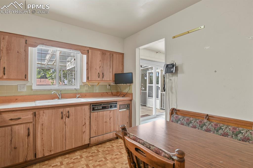 Image 11 of 26: Kitchen featuring light countertops, tasteful backsplash, and light brown c