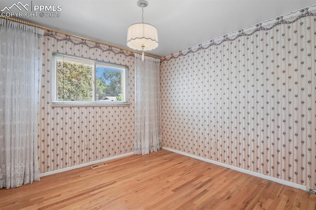 Image 16 of 26: Spare room featuring baseboards and wood finished floors