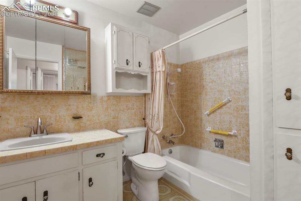 Image 17 of 26: Full bathroom featuring shower / bathtub combination with curtain, vanity, 
