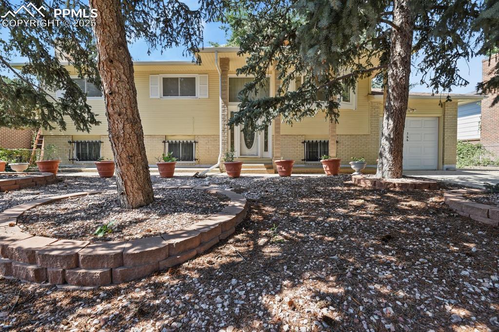 Image 26 of 26: Back of house featuring an attached garage and brick siding