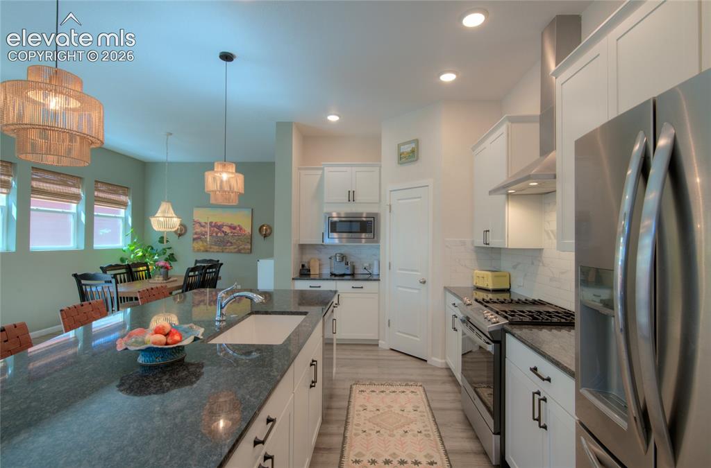 Image 10 of 35: Open-concept kitchen featuring an oversized island with an undermount sink,