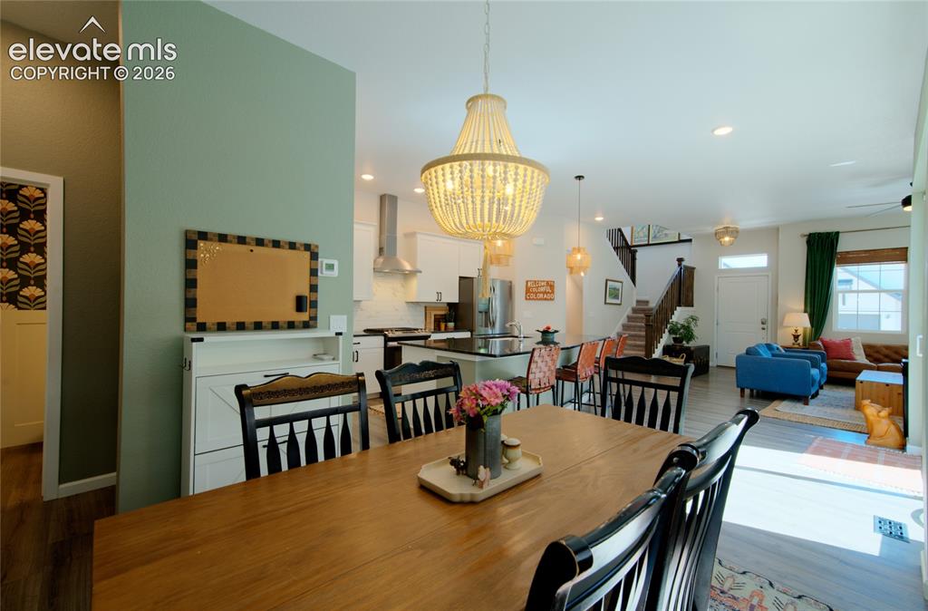 Image 14 of 35: Open-concept living area featuring a prominent dining space with wood-finis
