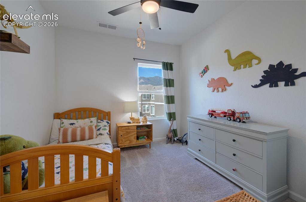 Image 18 of 35: Bright bedroom featuring a window with natural light, light gray carpeting,