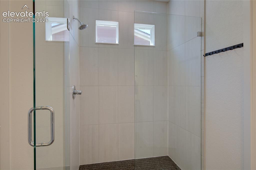 Image 24 of 35: Enclosed shower featuring clear glass panels, a chrome shower head and fauc