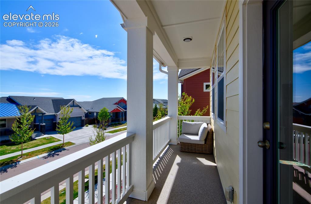 Image 26 of 35: Covered outdoor balcony featuring white railings and columns
