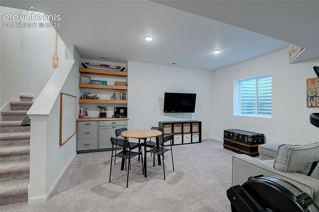 Image 28 of 35: Carpeted lower level featuring recessed lighting and a built-in cabinetry u