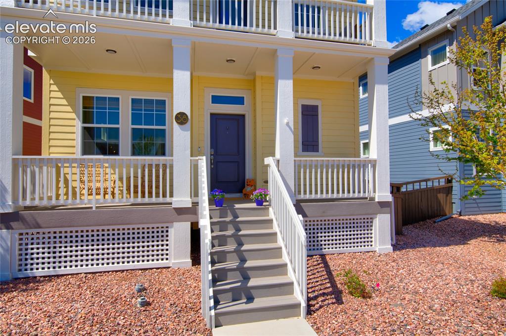 Image 3 of 35: Yellow exterior with white trim, a covered porch, and a second-story balcon