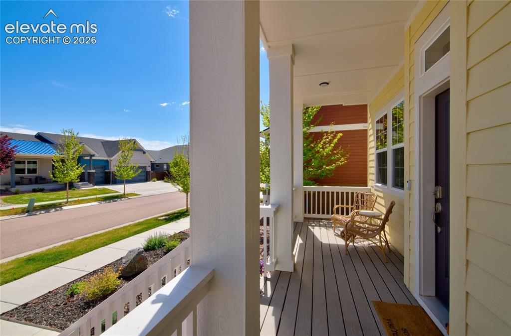 Image 4 of 35: Covered front porch featuring horizontal siding, durable decking, white rai