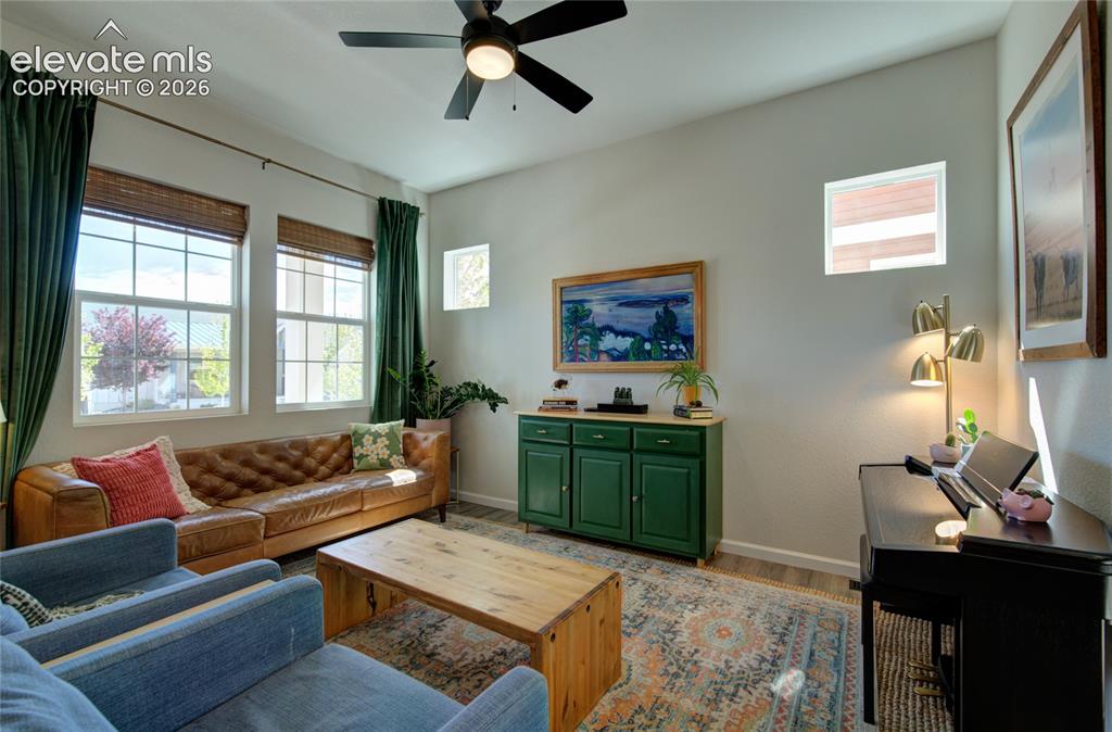 Image 6 of 35: Bright living area featuring multiple windows, wood-finish flooring, and a 