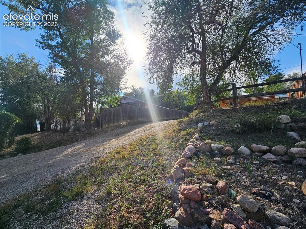 Image 29 of 37: Gravel driveway and stone hillside tiers