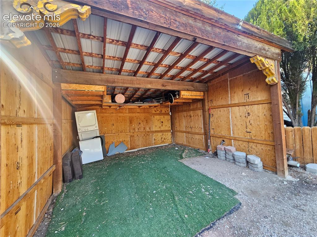Image 36 of 37: Partially enclosed carport with decorative corbels