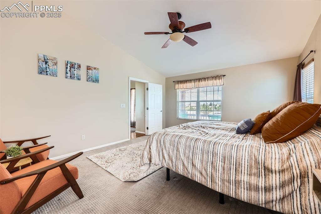 Image 11 of 49: Primary Bedroom with lofted ceiling, carpet, and a ceiling fan