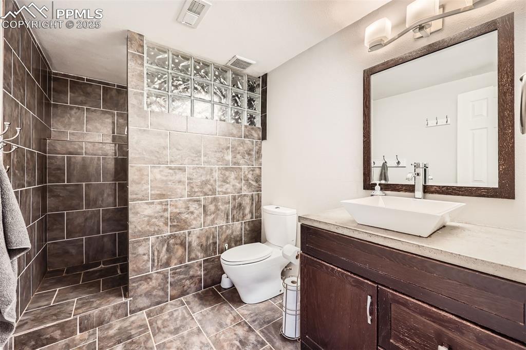 Image 19 of 49: Basement 3/4 bathroom featuring vanity and walk in shower