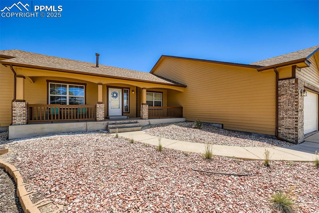 Image 2 of 49: Ranch-style house with a porch, an attached garage, roof with shingles, and