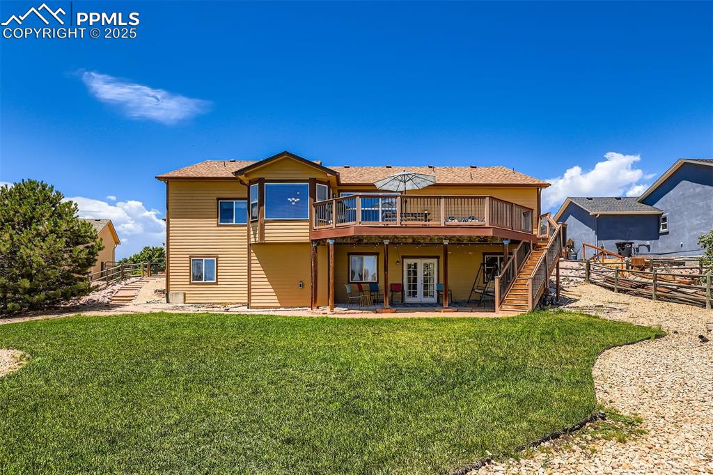 Image 27 of 49: Back of house with Trex stairs and deck, walkout level french doors, and co