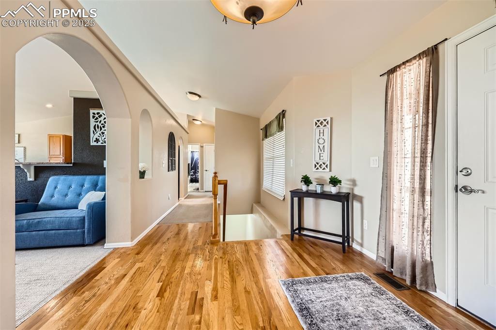 Image 3 of 49: Entryway with plenty of natural light wood flooring and arched walkways
