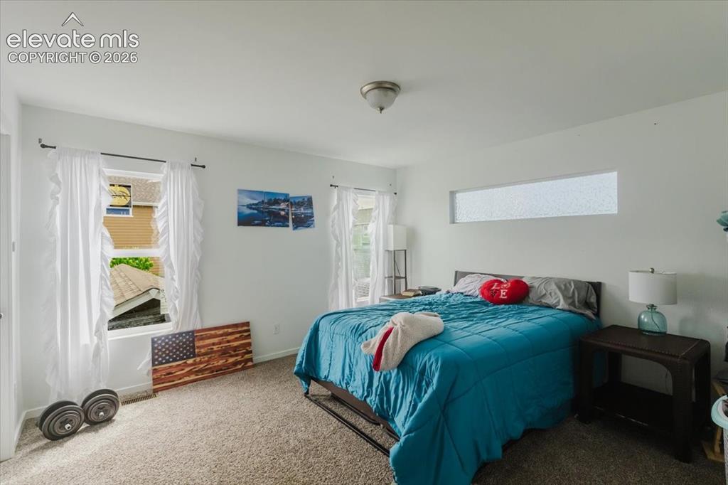 Image 14 of 33: Primary upstairs bedroom #1 with walkout to private patio overlooking Pikes