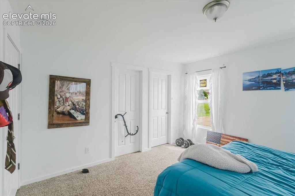 Image 15 of 33: Primary upstairs bedroom #1 with walkout to private patio overlooking Pikes