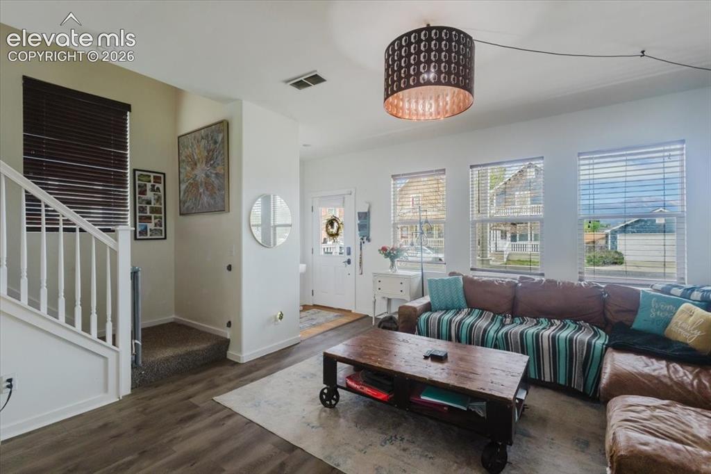 Image 4 of 33: Bright living room w gas fireplace & LVP flooring throughout main.