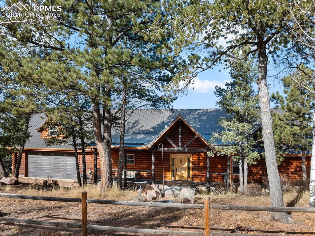 Caption: Beautiful custom build log home with fenced front, metal roof, separate workshop and majestic views.