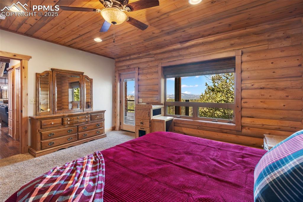 Image 22 of 46: Carpeted bedroom with access to exterior, wood ceiling, recessed lighting, 