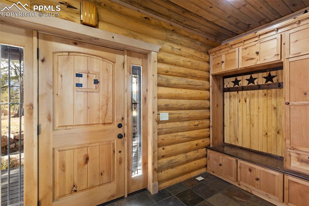 Image 8 of 46: Mudroom featuring rustic walls, healthy amount of natural light, and wood c