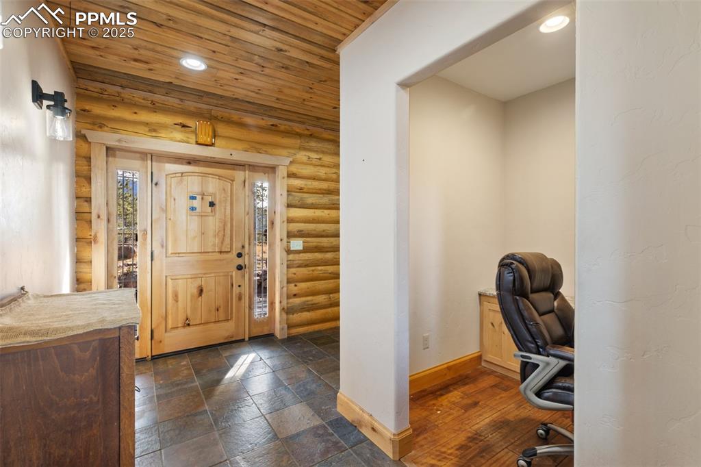 Image 9 of 46: Foyer featuring wooden ceiling, recessed lighting, log walls, and stone til