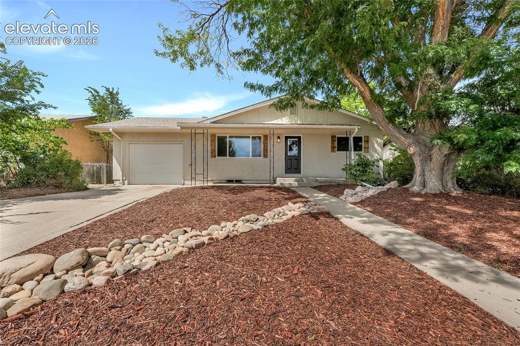 Caption: Single-story residence featuring a concrete driveway and an attached garage
