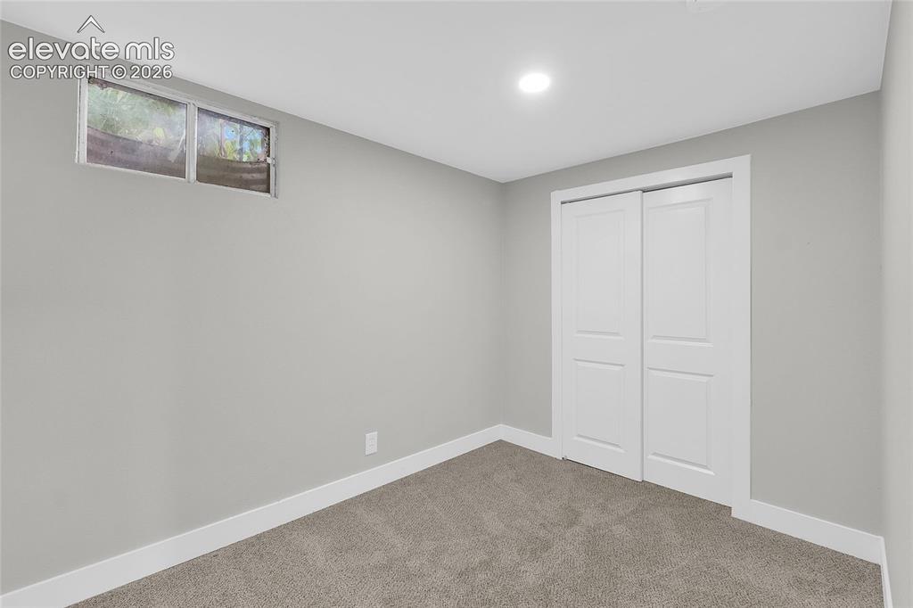 Image 18 of 27: Recessed ceiling lighting, gray wall paint, white trim, sliding closet door