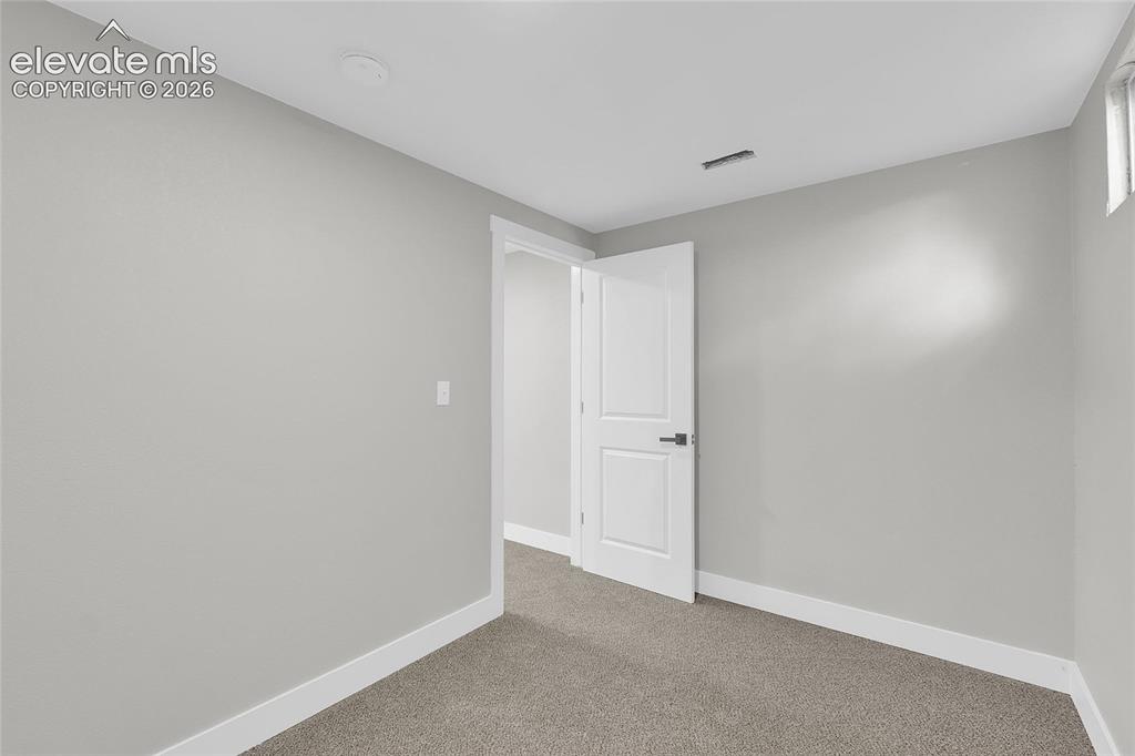 Image 19 of 27: Neutral color palette with light gray walls, white trim, and gray carpeting