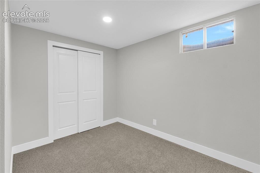 Image 20 of 27: Recessed ceiling lighting, light gray wall paint, gray carpet flooring, whi