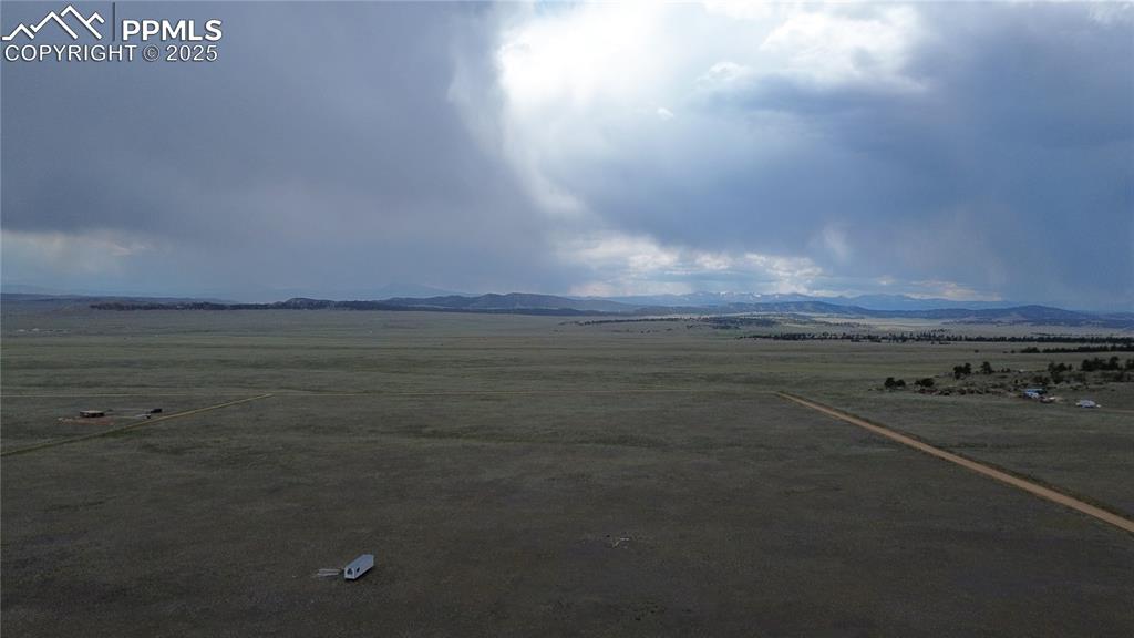 Image 3 of 8: Aerial view of sparsely populated area featuring a mountainous background