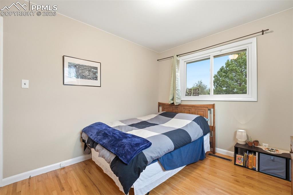 Image 21 of 47: Bedroom with baseboards and light wood-type flooring