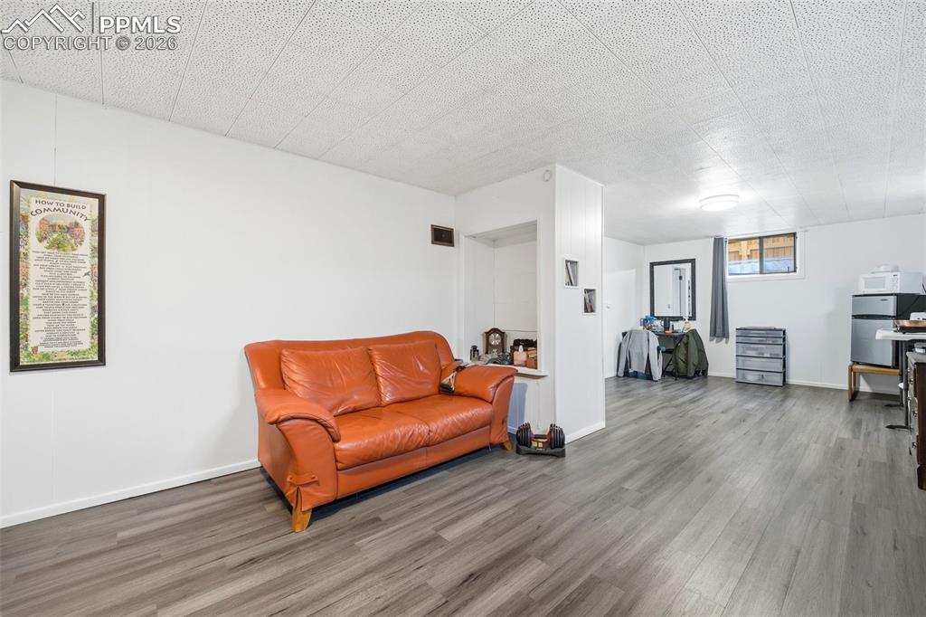 Image 26 of 47: Sitting room with wood finished floors