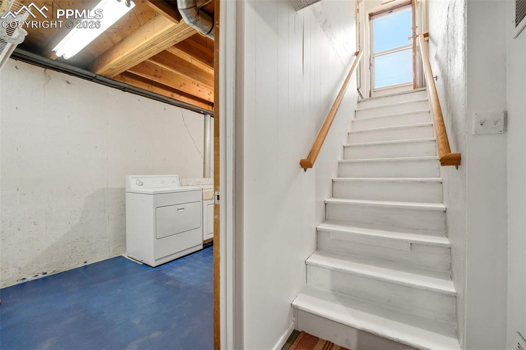 Image 33 of 47: Stairs featuring washer / dryer and concrete floors