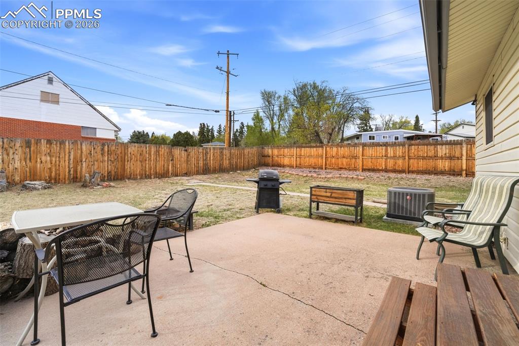 Image 39 of 47: Fenced backyard featuring a patio area, outdoor dining area, and a grill