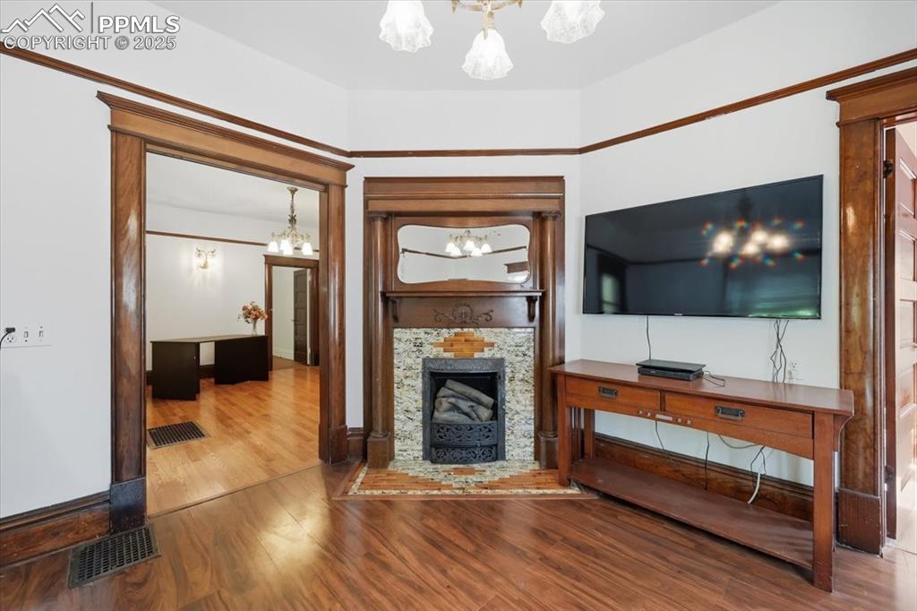Image 10 of 23: Unfurnished living room featuring a chandelier, wood finished floors, and a