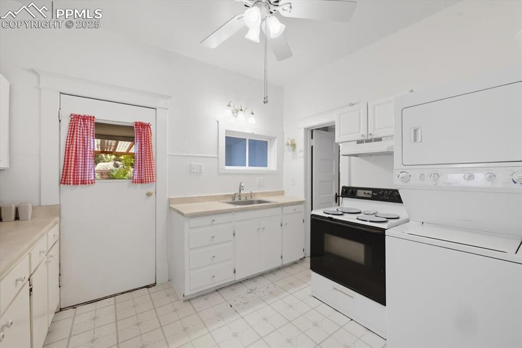 Image 13 of 23: Kitchen featuring range with electric stovetop, light countertops, white ca