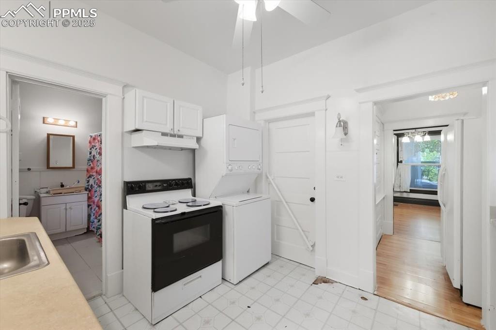 Image 16 of 23: Kitchen featuring white electric range, light countertops, under cabinet ra