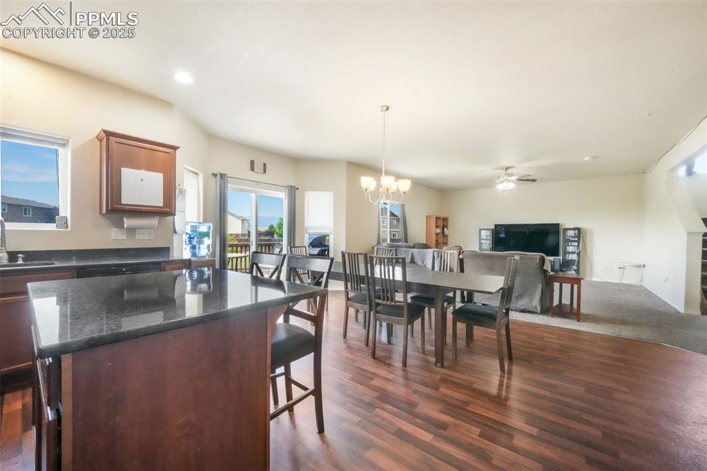 Image 14 of 48: Kitchen with a kitchen breakfast bar, a kitchen island, dark stone counters