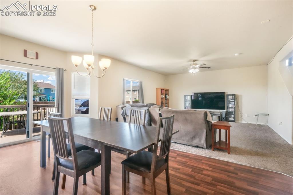 Image 15 of 48: Carpeted dining room with healthy amount of natural light, a chandelier, wo