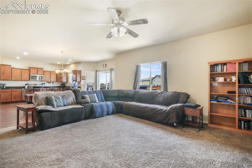 Image 16 of 48: Living room with a chandelier, a ceiling fan, carpet, and recessed lighting