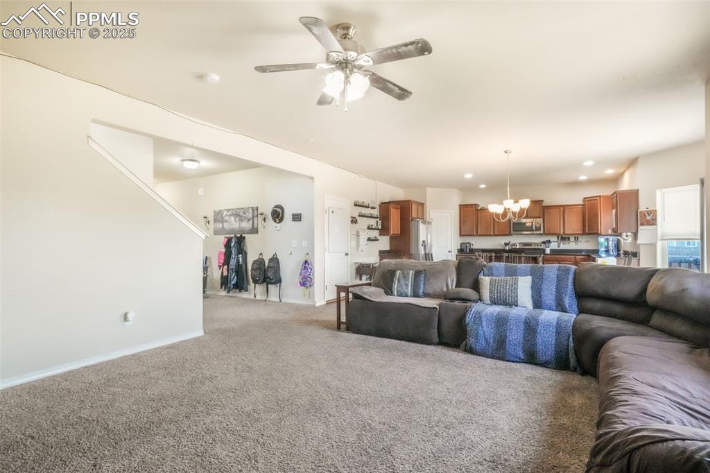 Image 17 of 48: Living area with a chandelier, light carpet, ceiling fan, and recessed ligh