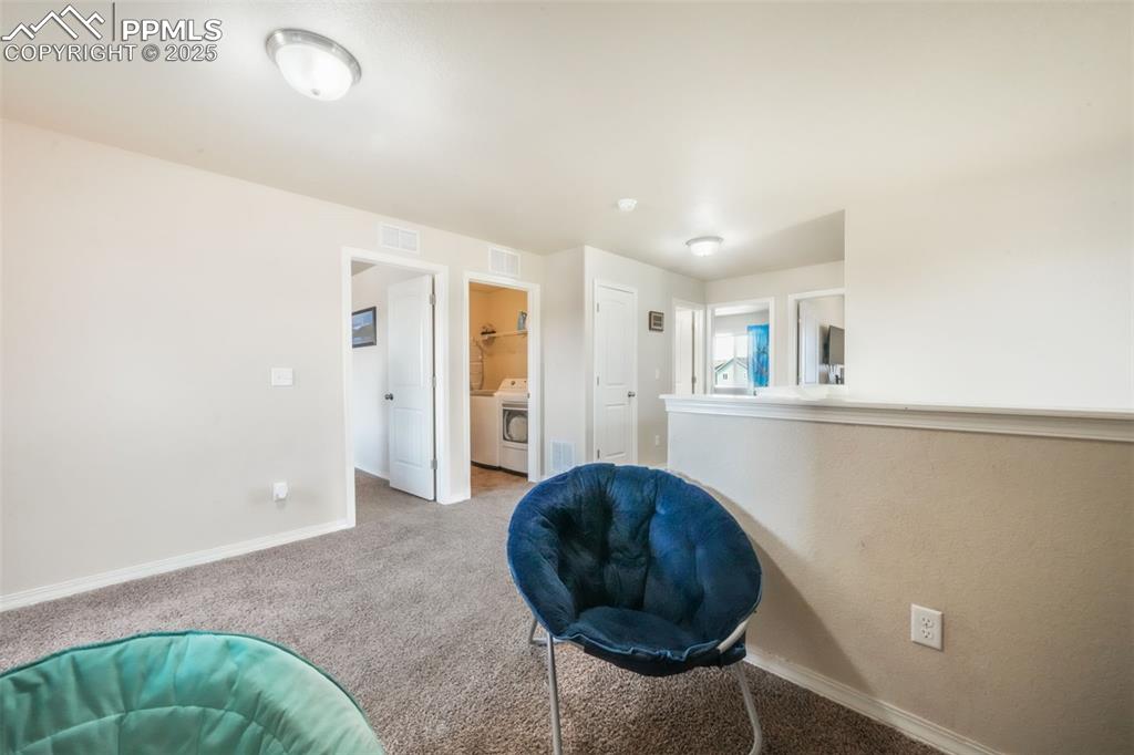 Image 22 of 48: Living area featuring baseboards and carpet flooring