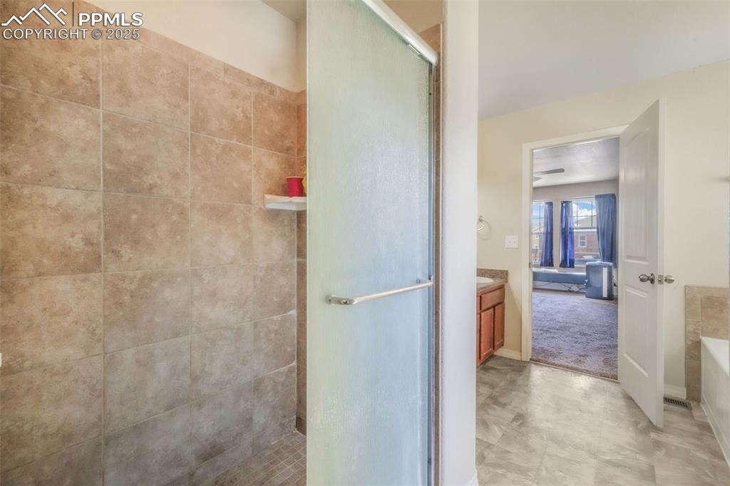 Image 28 of 48: Full bath featuring a stall shower, vanity, and a garden tub