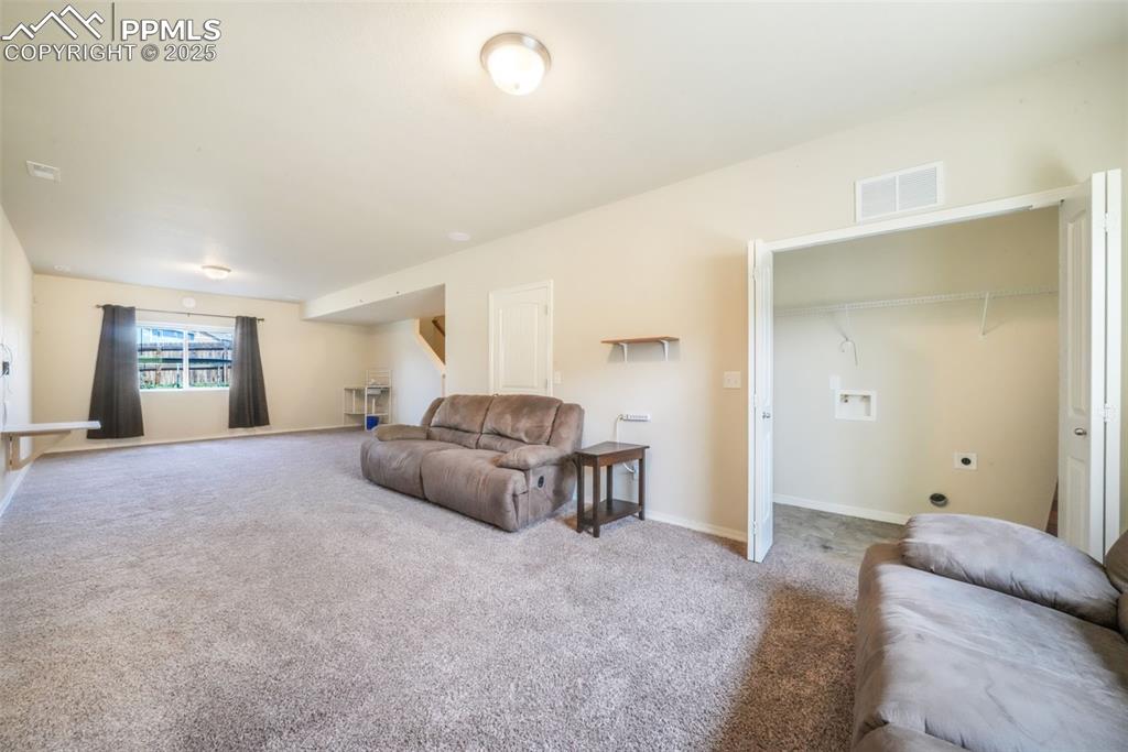 Image 39 of 48: Living room featuring carpet flooring and baseboards