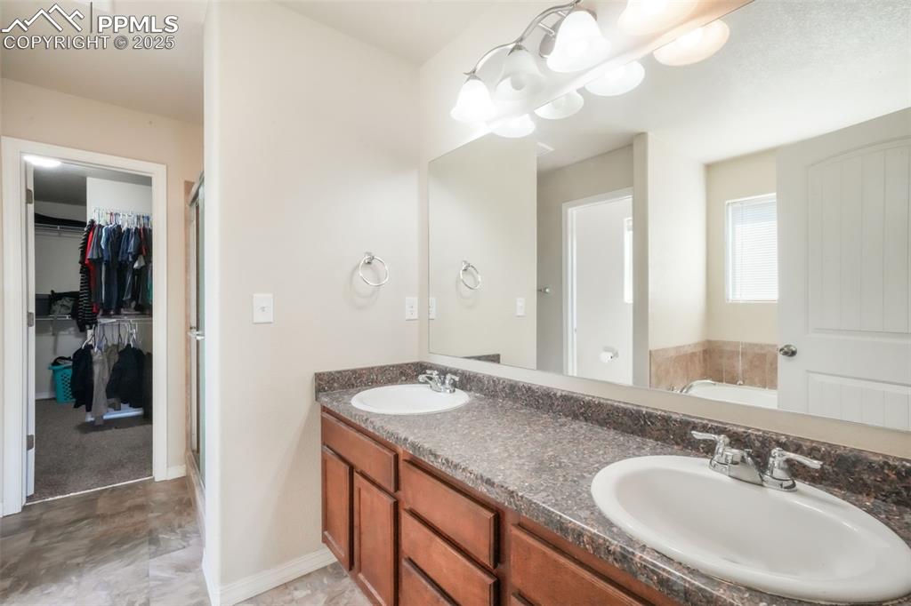 Image 44 of 48: Full bathroom featuring a garden tub, a stall shower, and a walk in closet