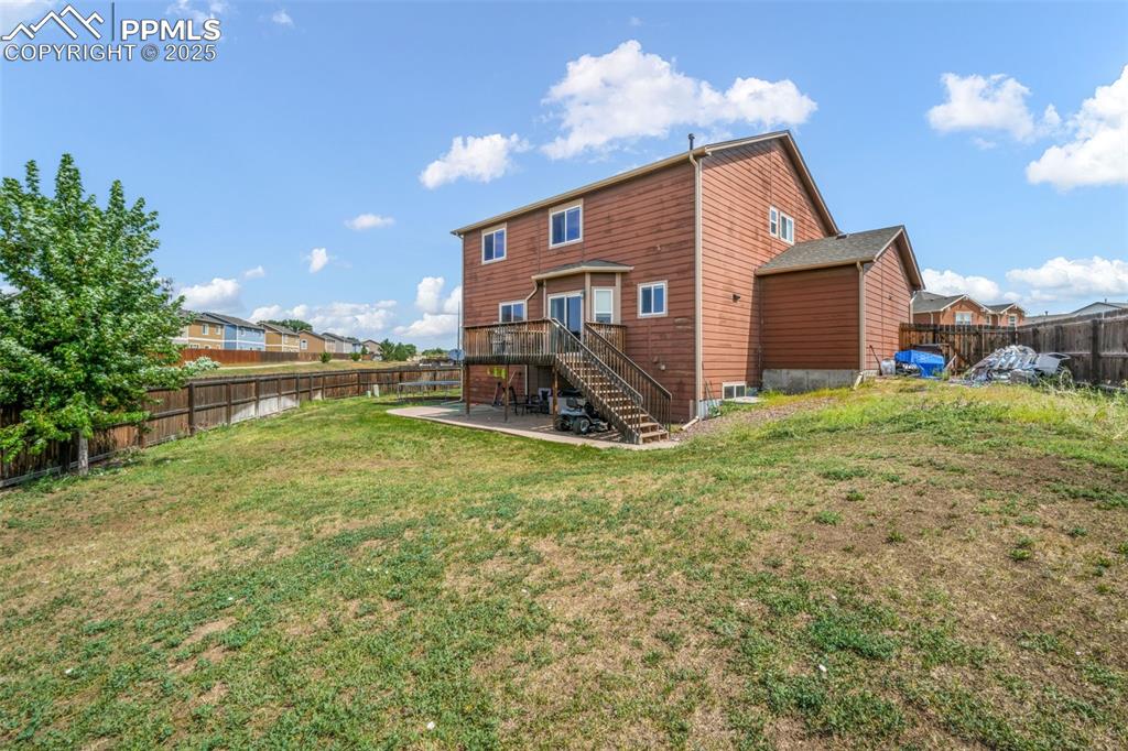 Image 46 of 48: Back of house with stairway, a fenced backyard, a wooden deck, and a reside