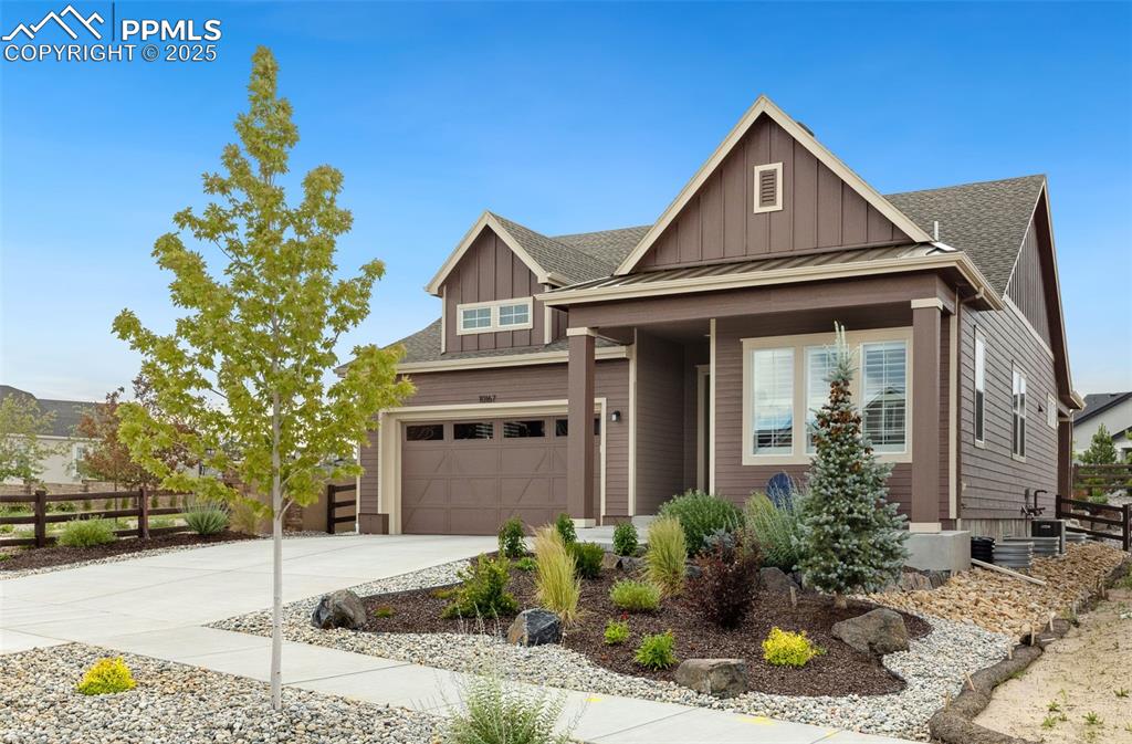 Image 10 of 49: Craftsman-style home featuring board and batten siding, driveway, a garage,